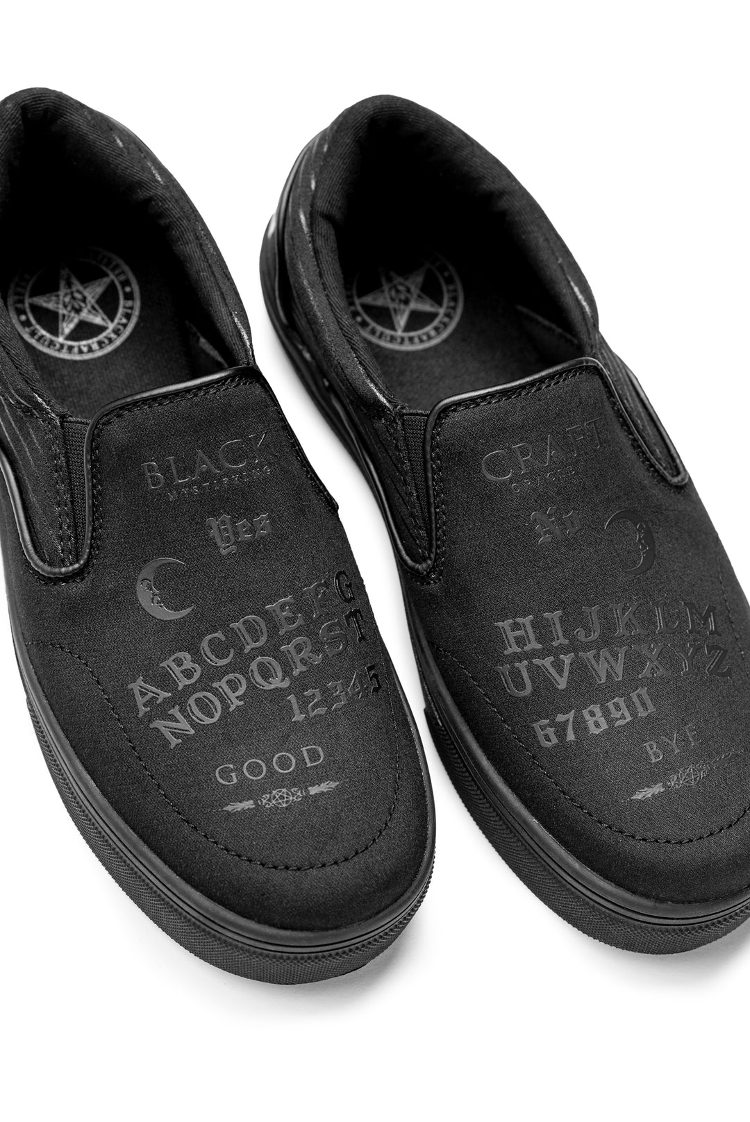 A slip on sneaker featuring our signature Ouija artwork on black canvas fabric upper and custom Blackcraft logo rubber sole.