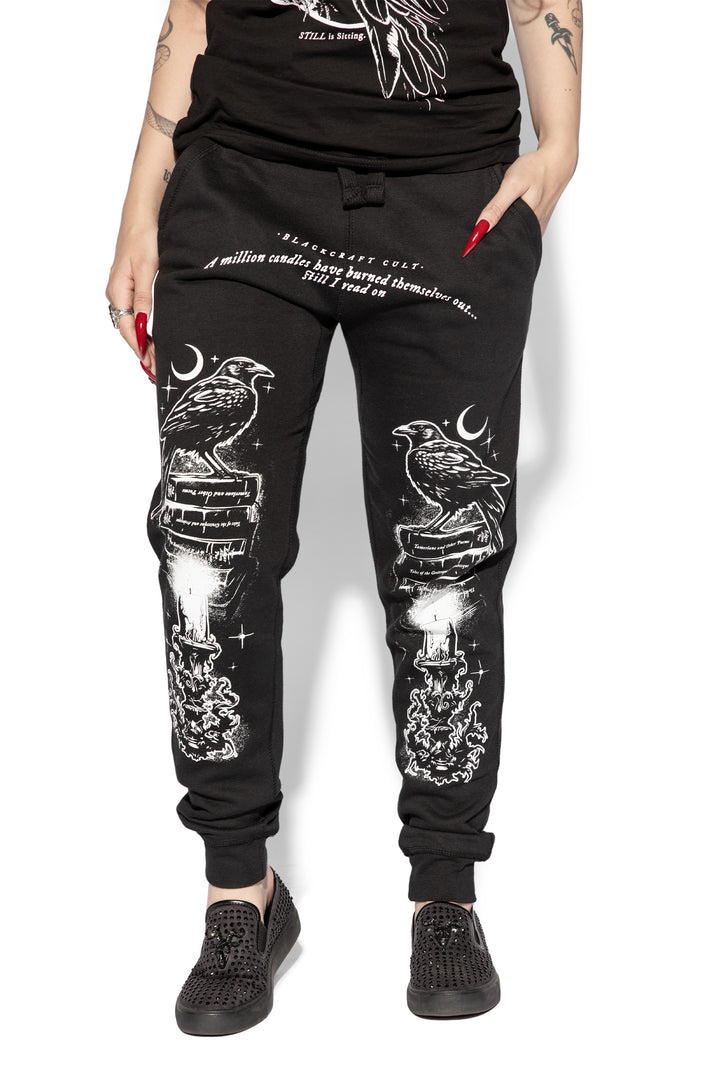 A model wearing a pair of classic fit black joggers with custom Blackcraft artwork along the front of each leg.