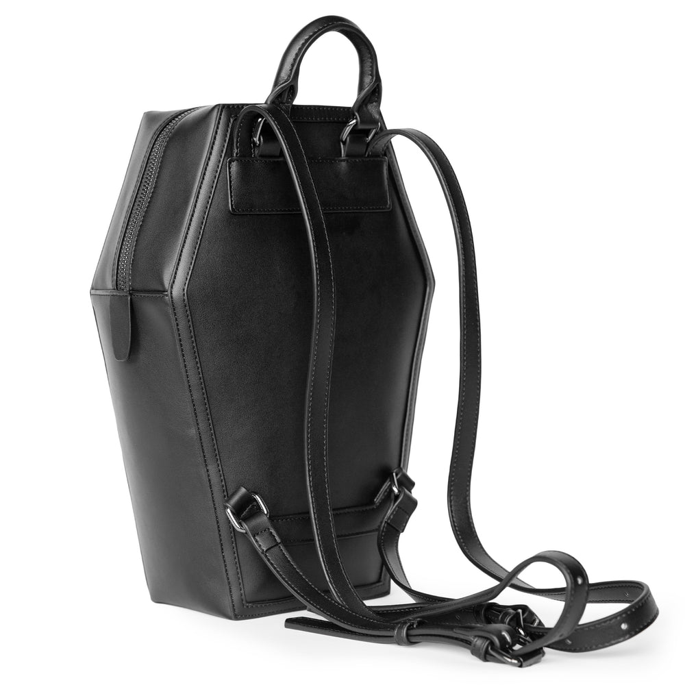 Black faux leather coffin shaped backpack with I Believe in Ghosts Stories art embossed on front.