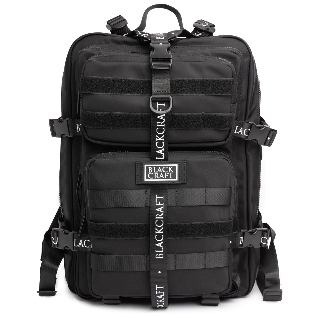 Large black nylon backpack with Blackcraft rubber logo, functional buckles, and logo strap details. 