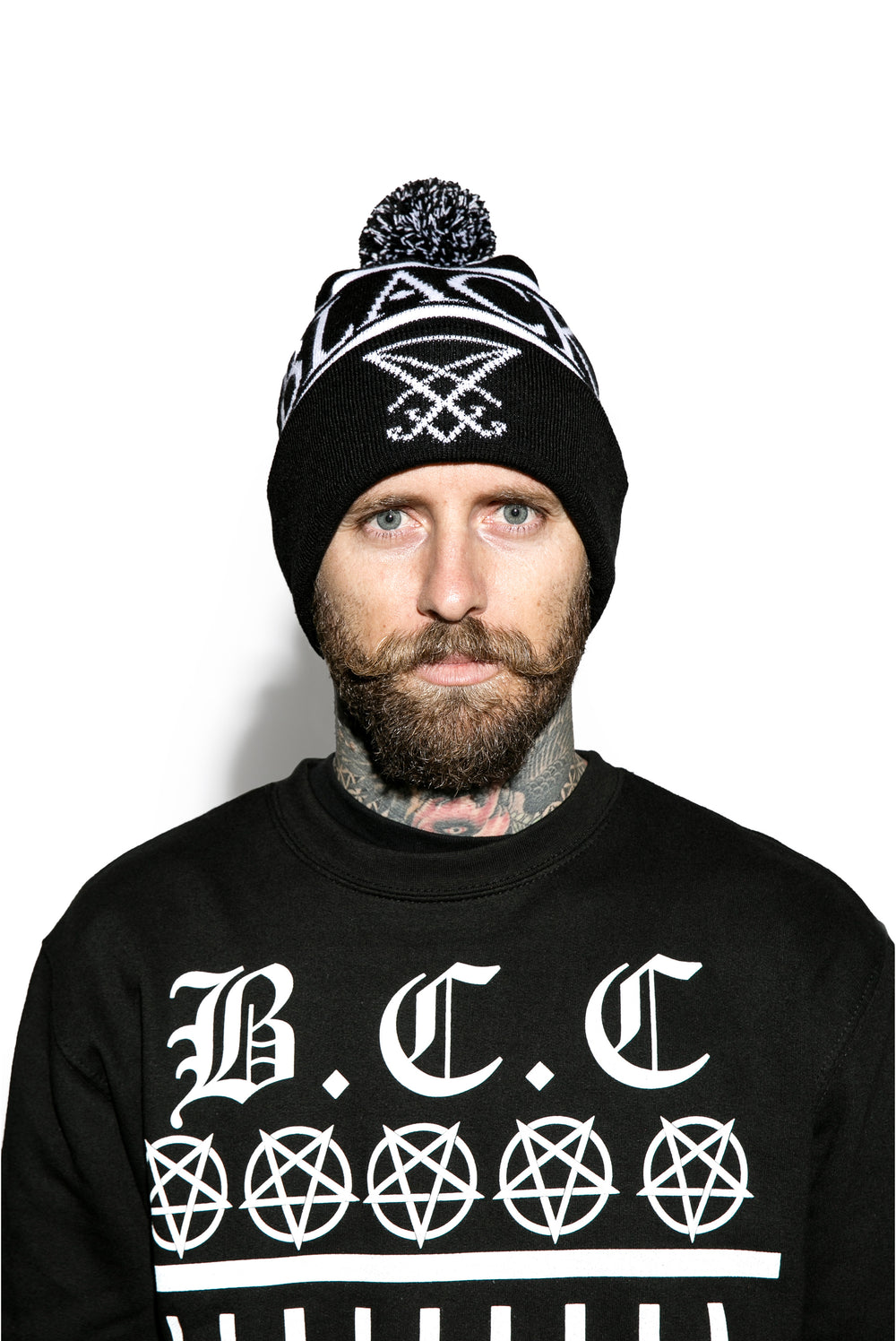 Model wearing a black bobble beanie with Blackcraft across the circumference.