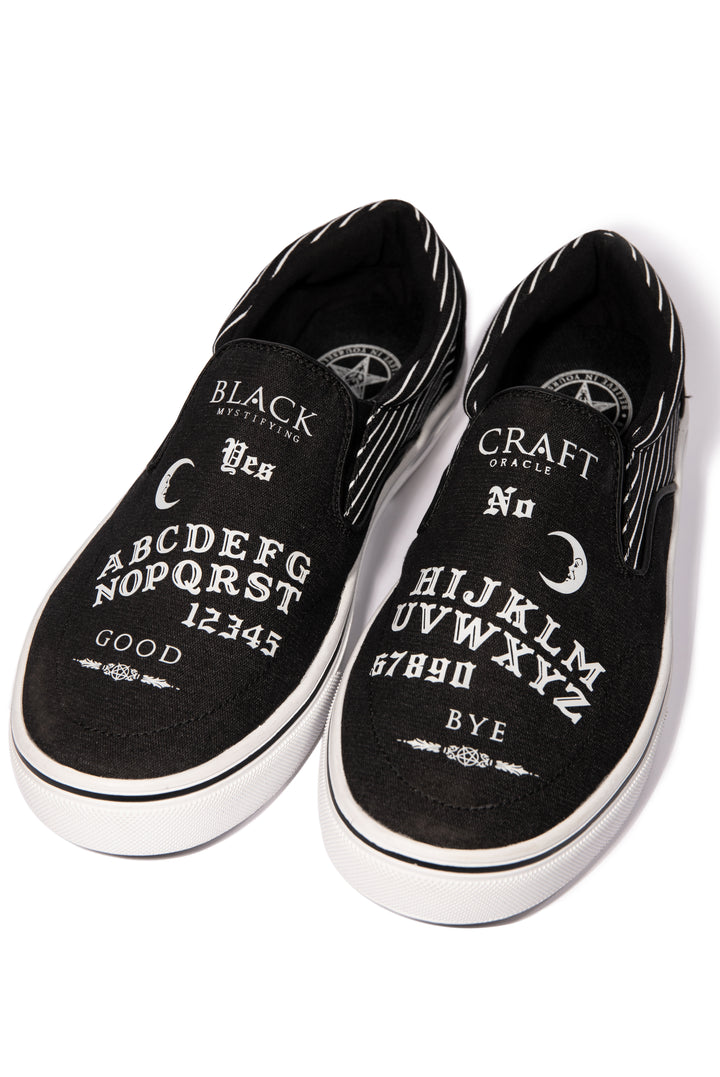 A slip on sneaker featuring our signature Ouija artwork on black canvas fabric upper and custom Blackcraft logo rubber sole.