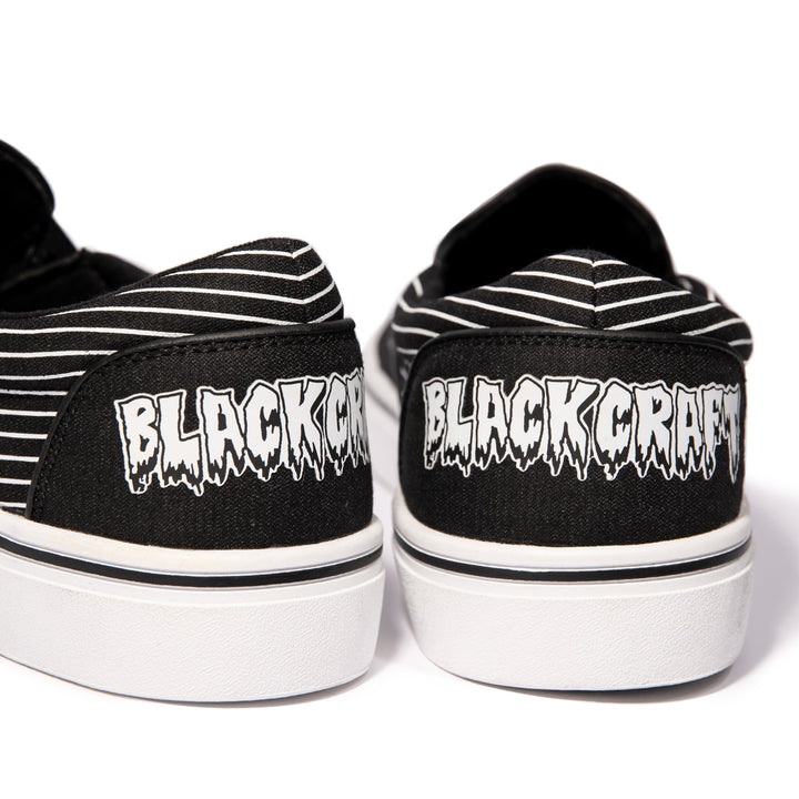 A slip on sneaker featuring our signature Ouija artwork on black canvas fabric upper and custom Blackcraft logo rubber sole.